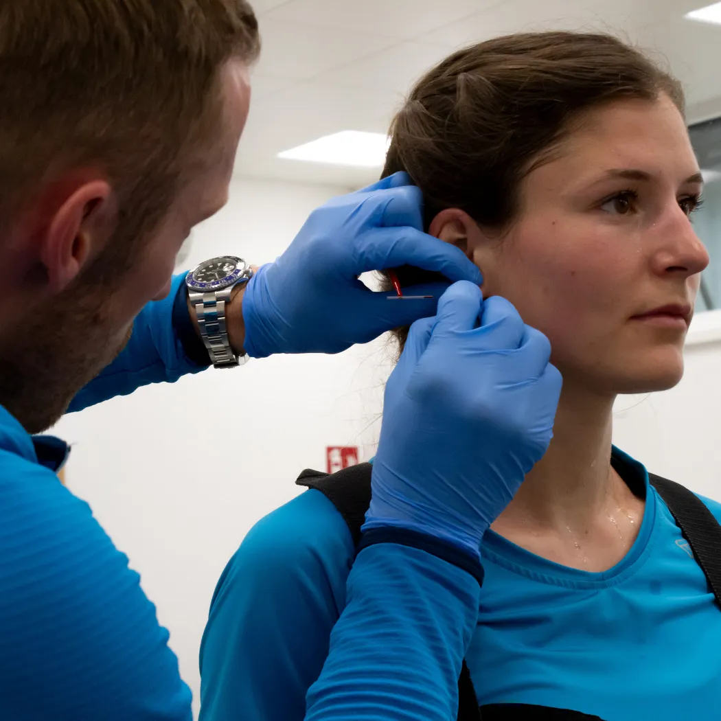 Person in blauer Kleidung führt einen Test an einer Frau durch